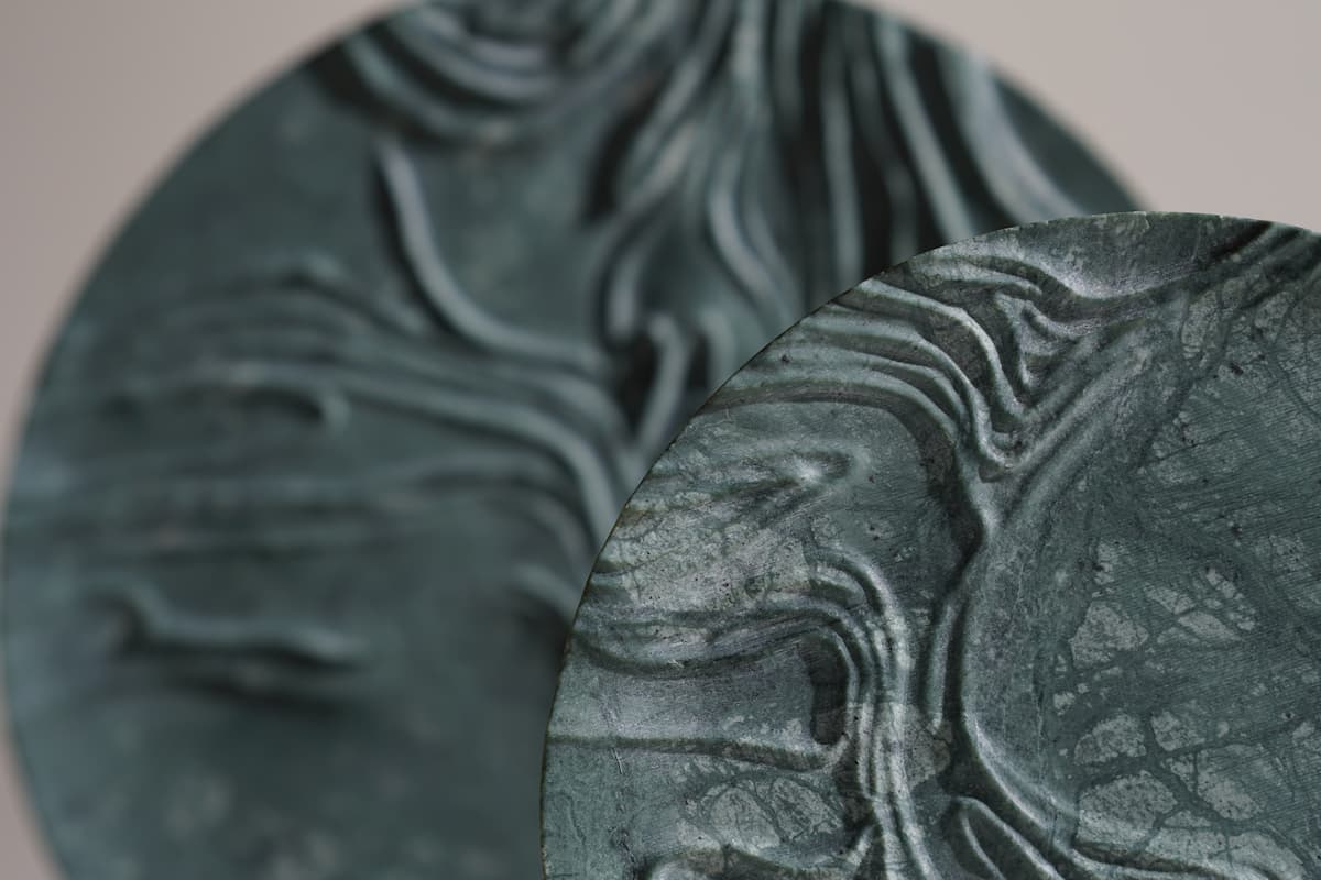 Close up of  green stoneware plates, with textured ridges.