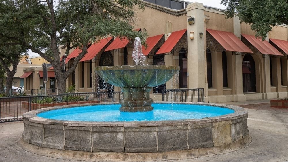 A stone fountain in a city courtyard.