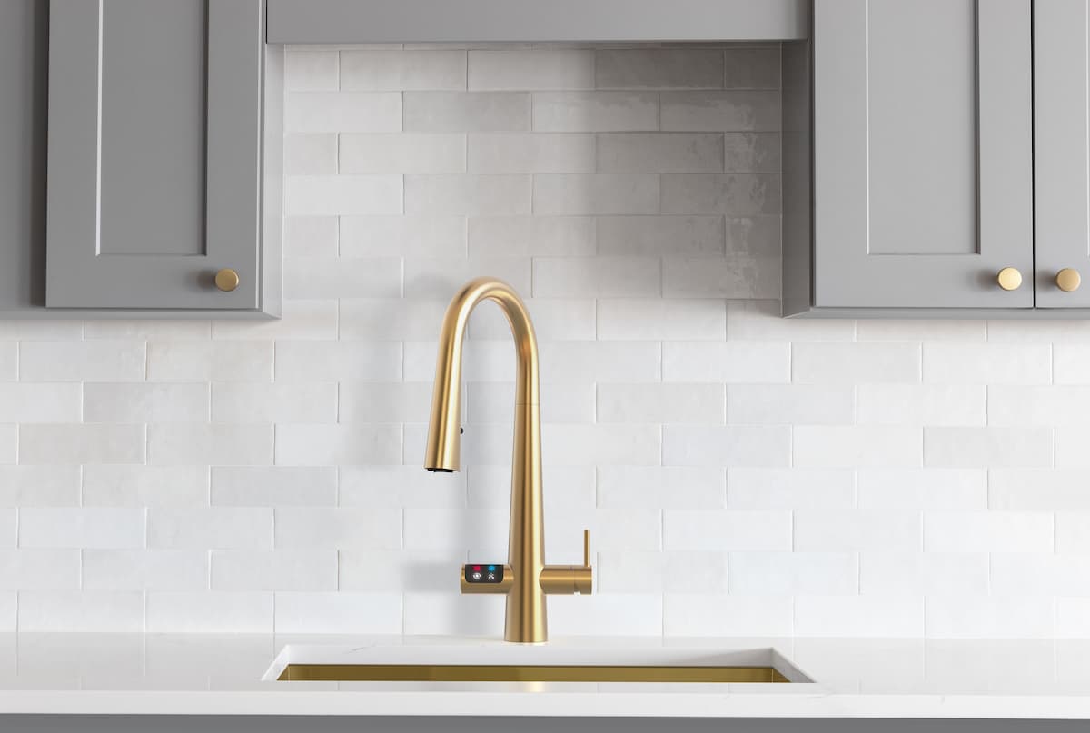 gold faucet with touchscreen in grey and white kitchen, quartz counters
