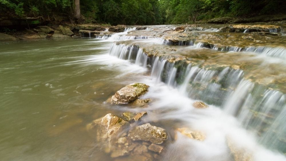 A close up of a small waterfall in a river.