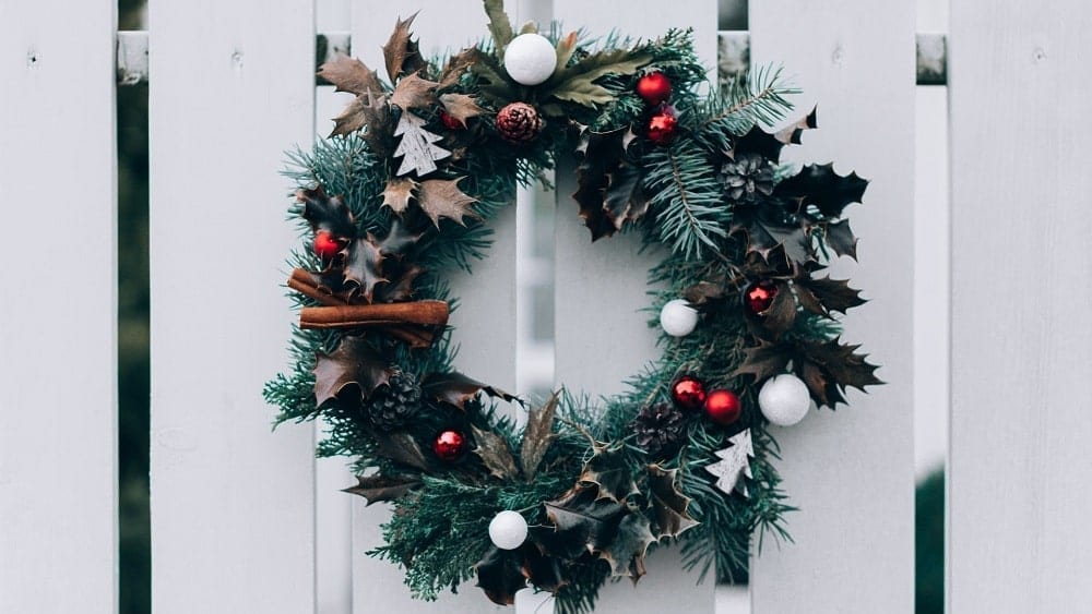 Christmas wreath hanging on fence.
