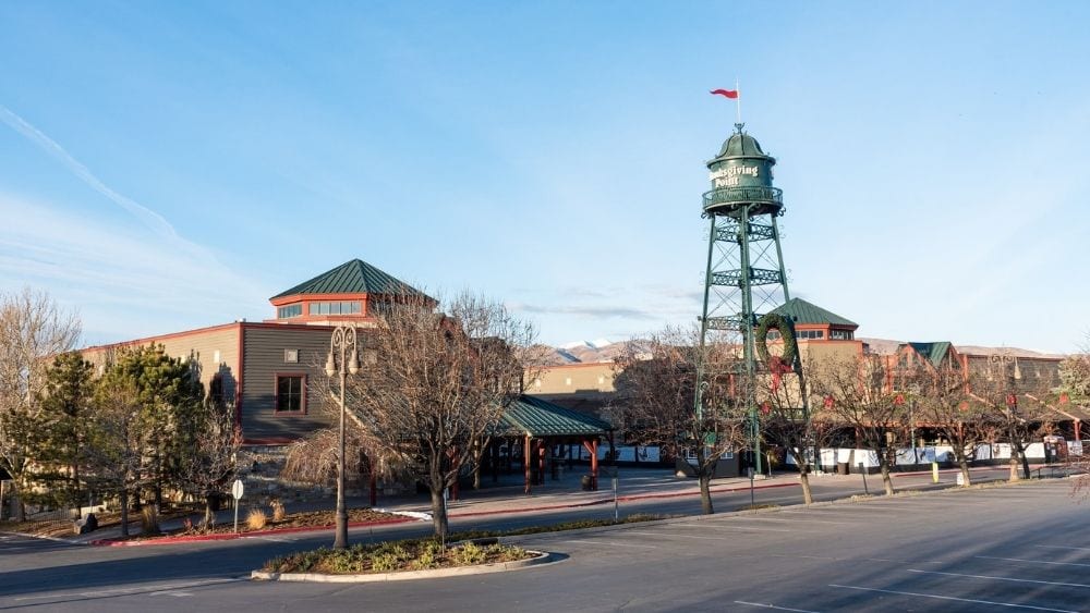 A museum with an old green water tower in front.