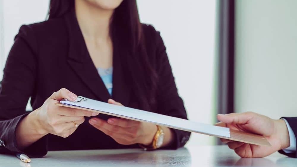 attorney passing clipboard to client