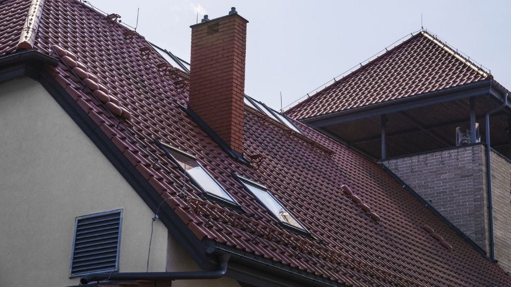 A slanted red ceramic roof with solar panels.