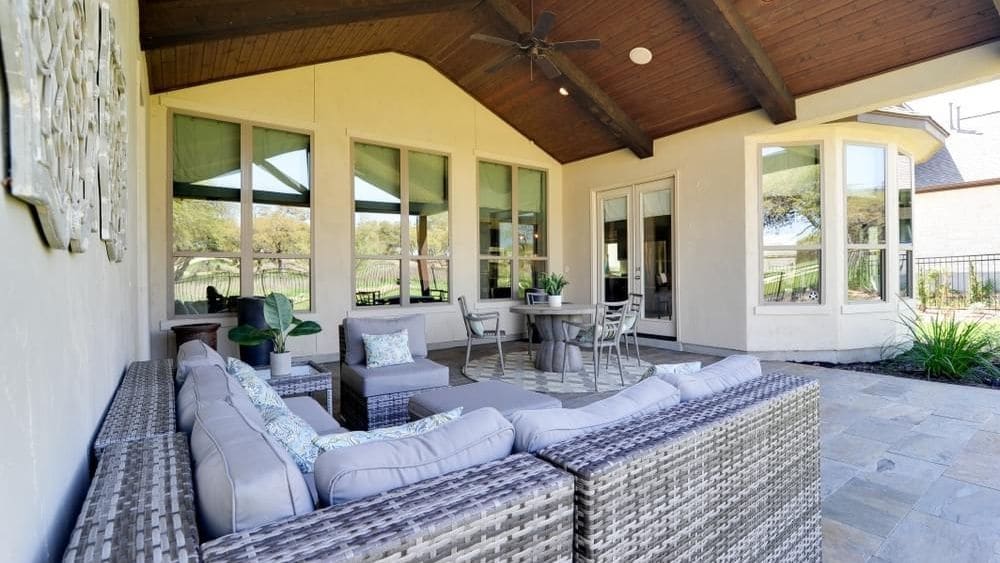 A back patio with a comfy couch and a vaulted ceiling.