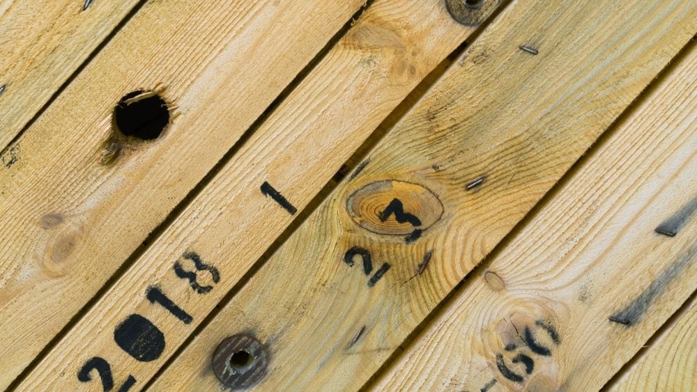 Close-up of lumber stamped with numbers for shipment.