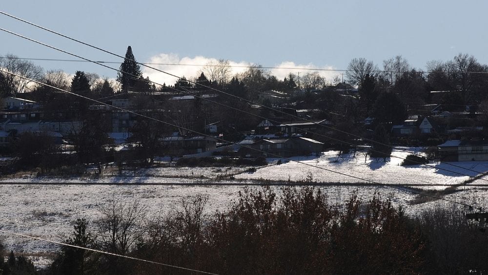 Suburban homes with snow on the roofs and ground.