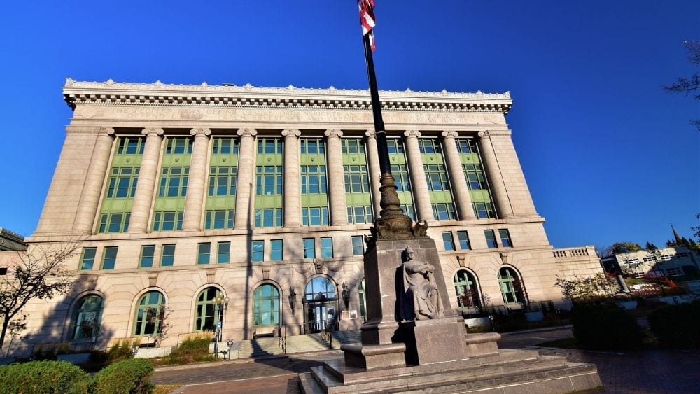 Photo of the St. Louis County Town Hall with a flag post in front.