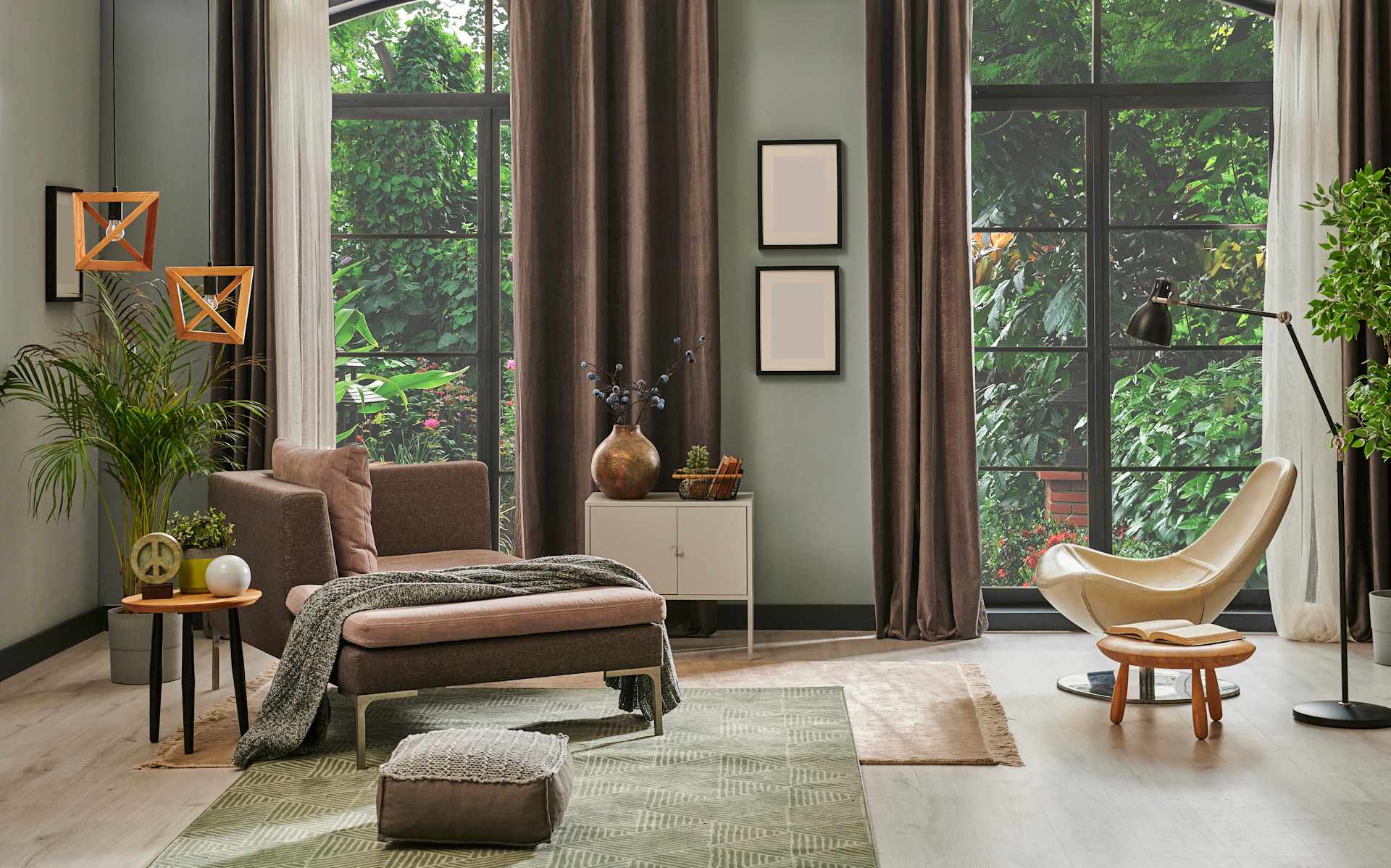 Living room with green walls, greenery outside the window, curved chair lots of plants and wingback chair