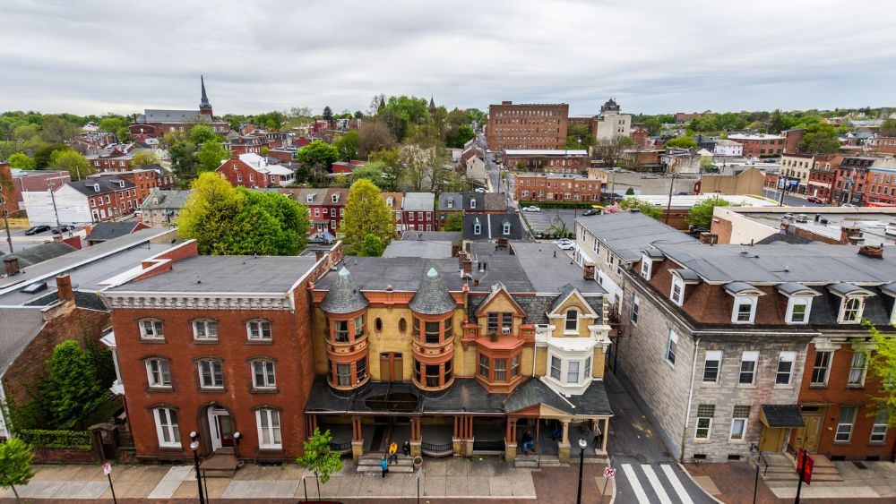 A collection of multi-colored buildings on a city block in Lancaster, PA, with more of the town in the far background