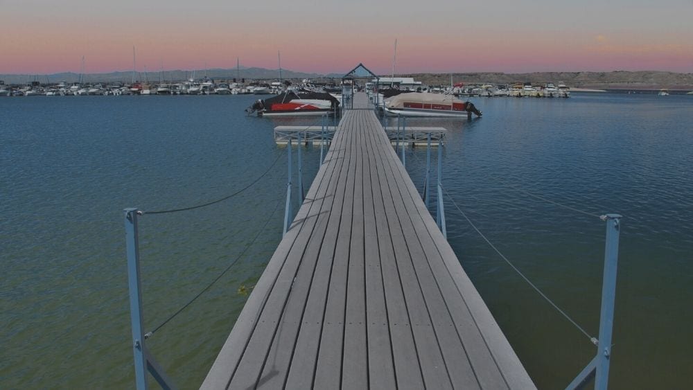 View looking down a pier toward docked boats.