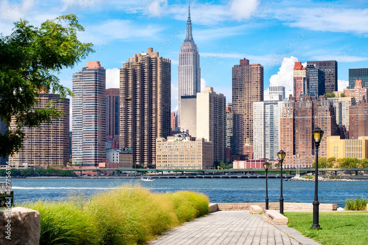 view from park across the water looking at Manhattan skyscrapers