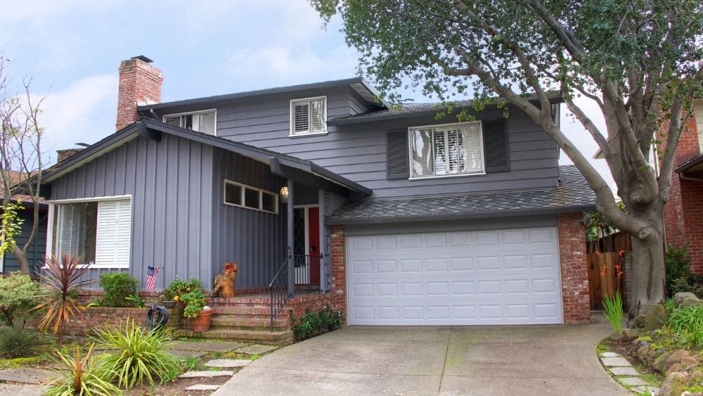 Ranch-style home with grey vertical wood siding.