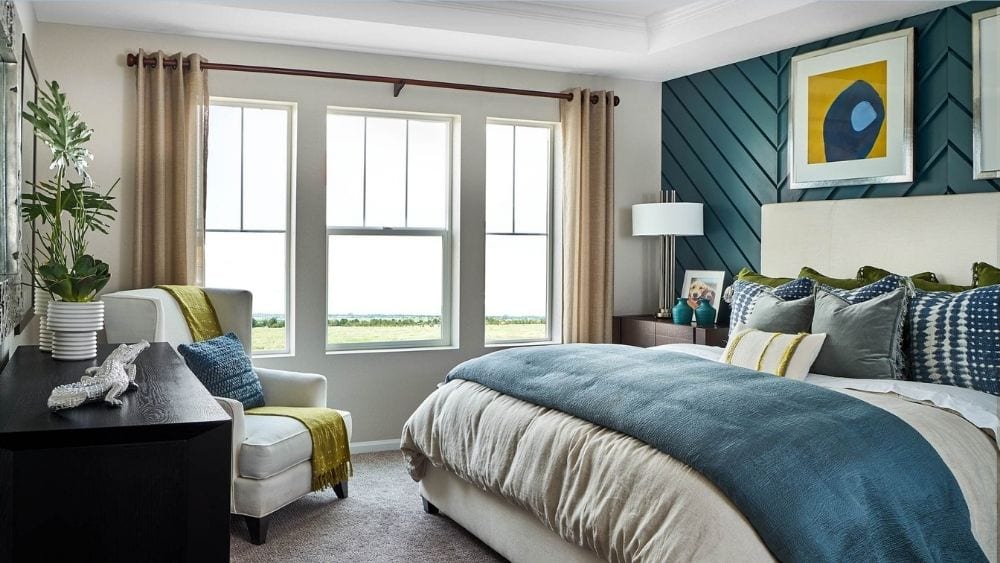 A bedroom with large windows and a king-sized bed.