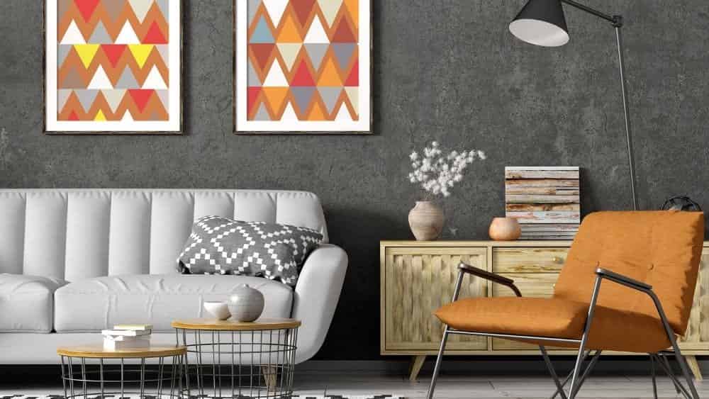 modern interior design, with green walls, a pair of geometric prints in white frames, a yellow armchair, and tufted sofa and a wooden credenza