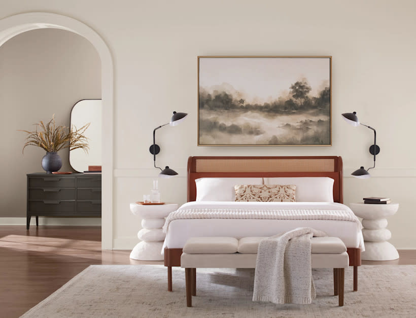 bedroom with queen size bed, rattan headboard, landscape print, curved bedside tables and curved doorway