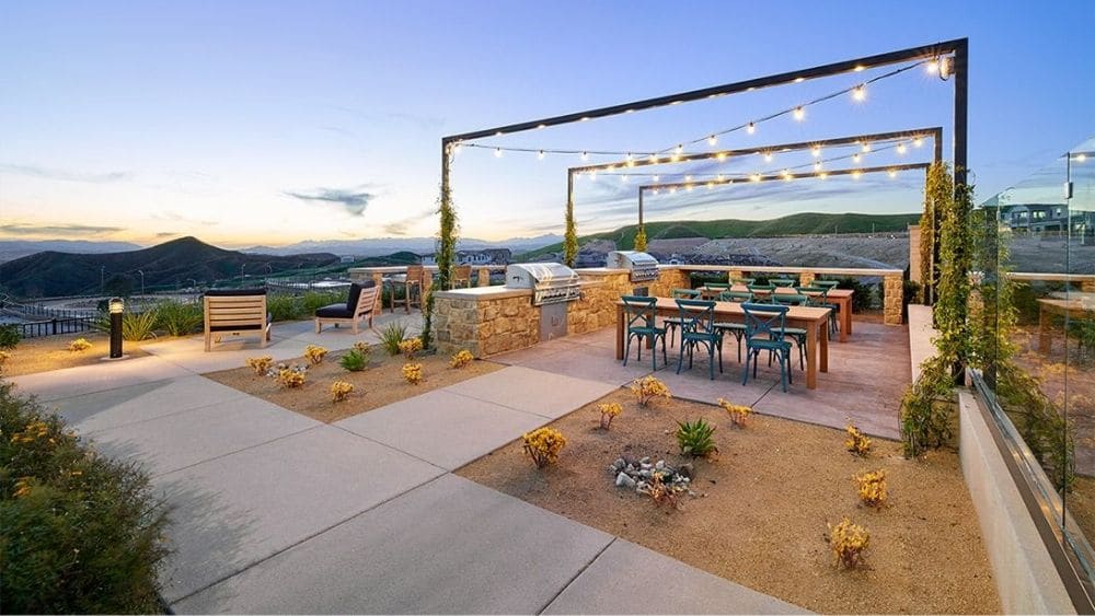 Courtyard with xeriscaped grounds and modern lighting over picnic tables.