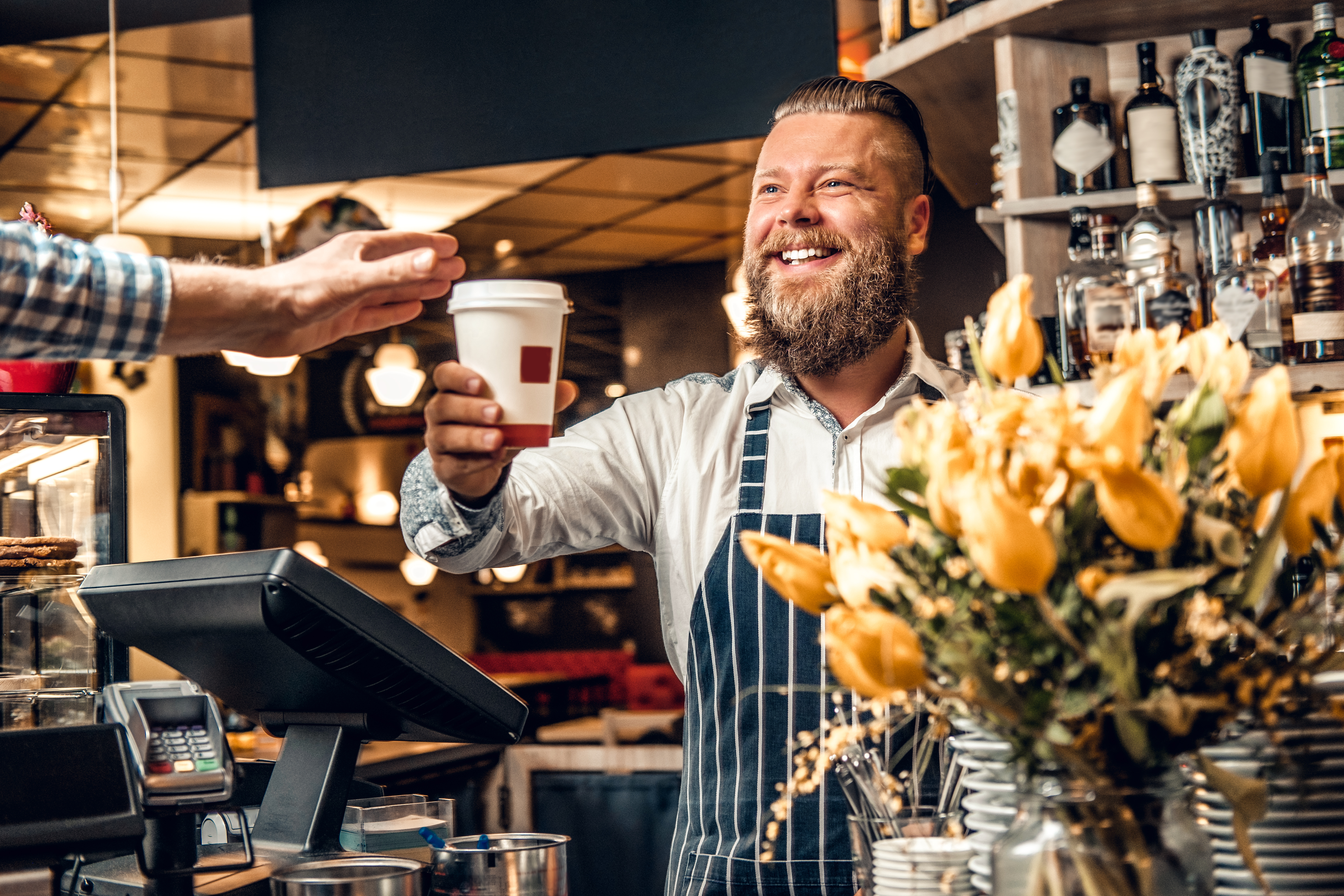 barista handing man a coffee