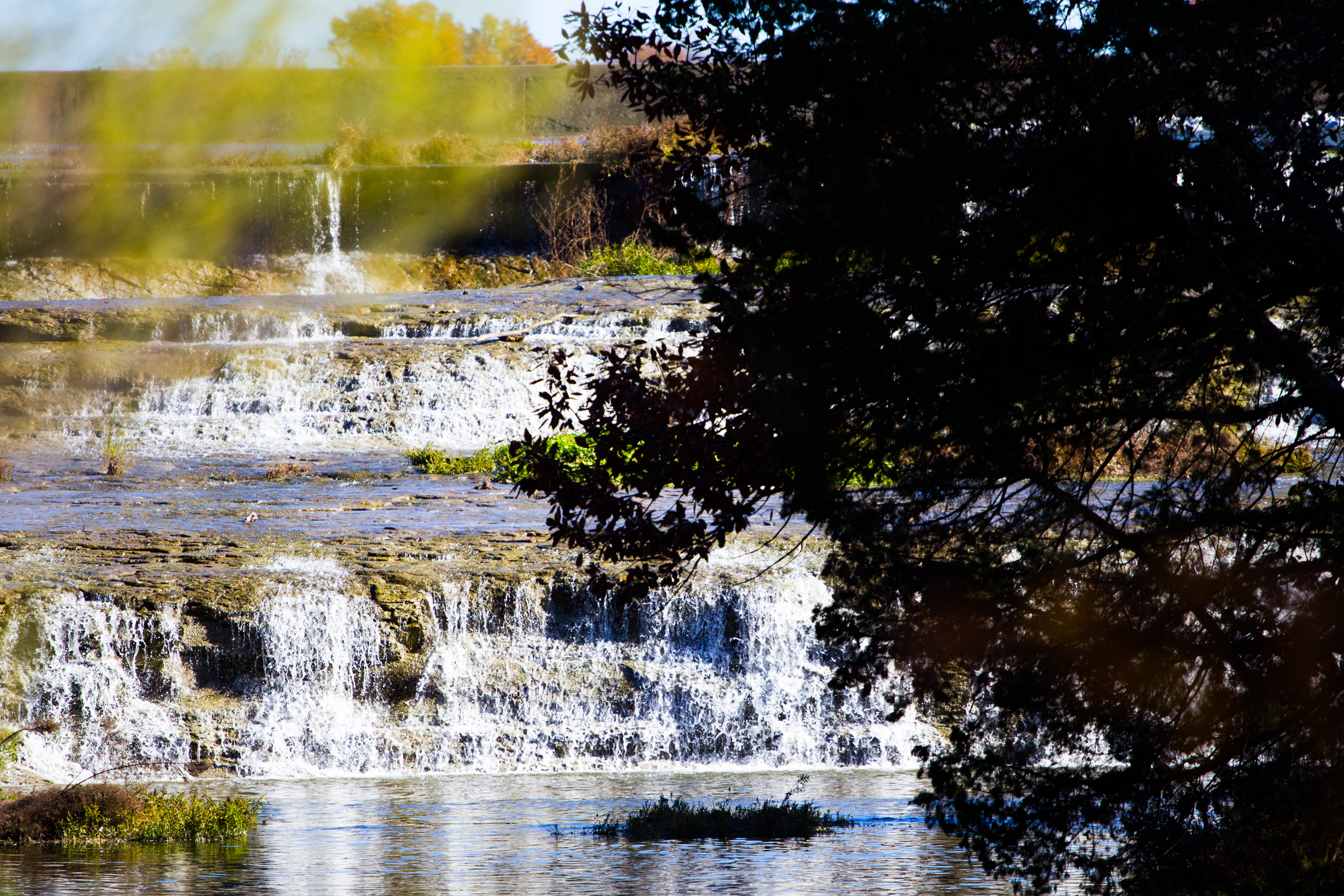 waterfall at white rock lake with trees in the foreground