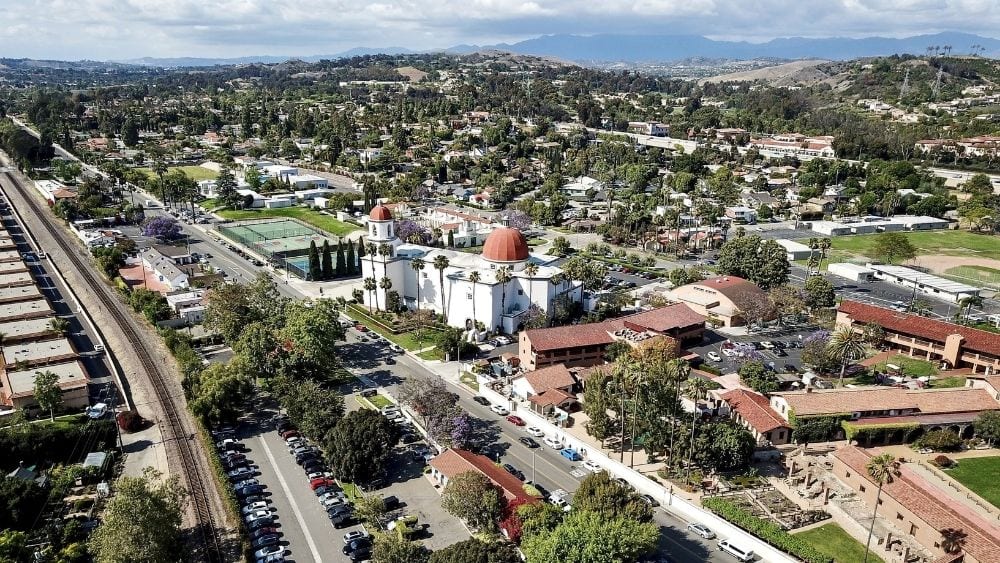 Aerial view of a suburb with lots of greenspace and commercial buildings.