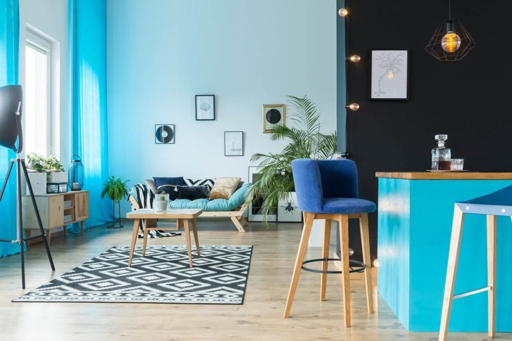 blue-velvet-chair-with-wooden-legs-featured-in-a-new-home-living-space