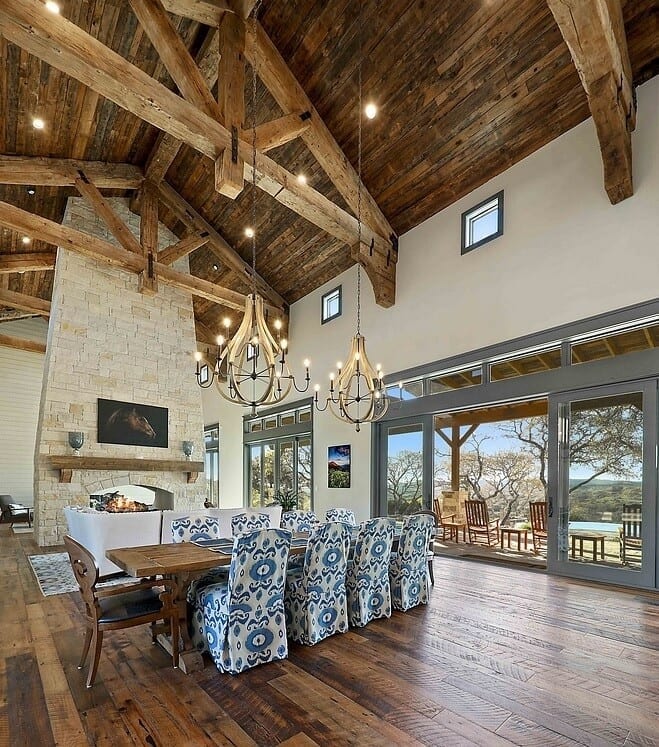 Ranch-style great room with vaulted ceiling made of natural wood and a floor-to-ceiling stone fireplace