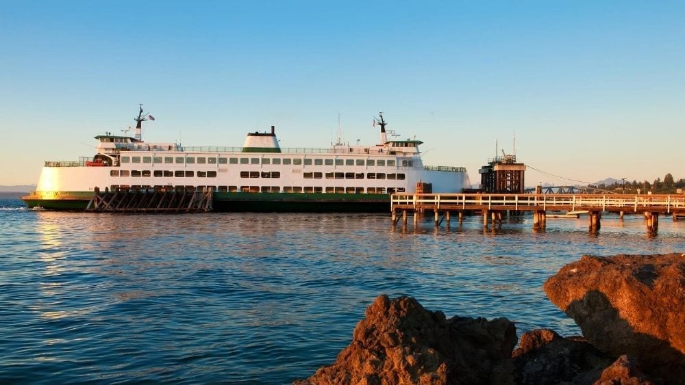 A cruise ship docked at a pier at sunset.