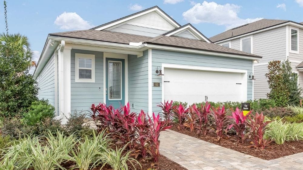 Light blue home with a stone path leading to the front door.