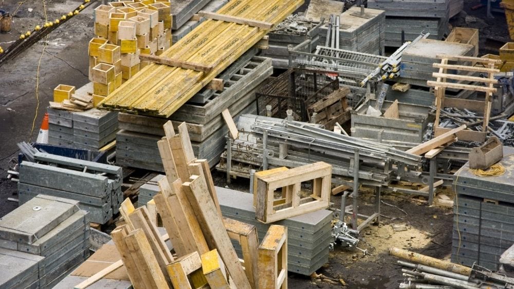 Construction materials stacked in a concrete area.