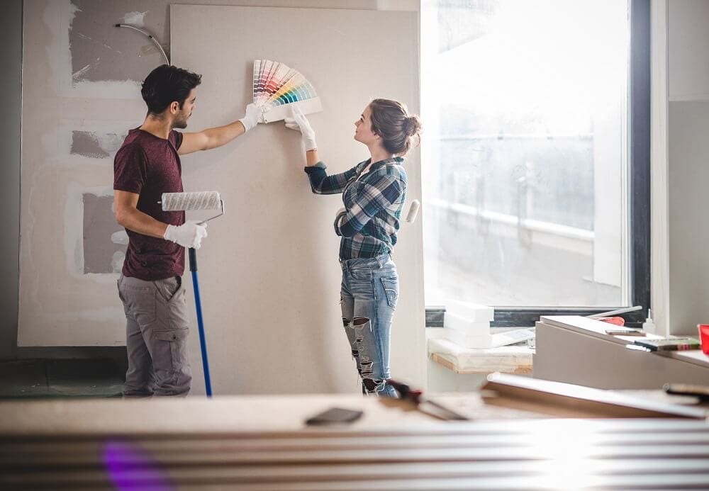 Couple looking at color swatches to renovate apartment paint