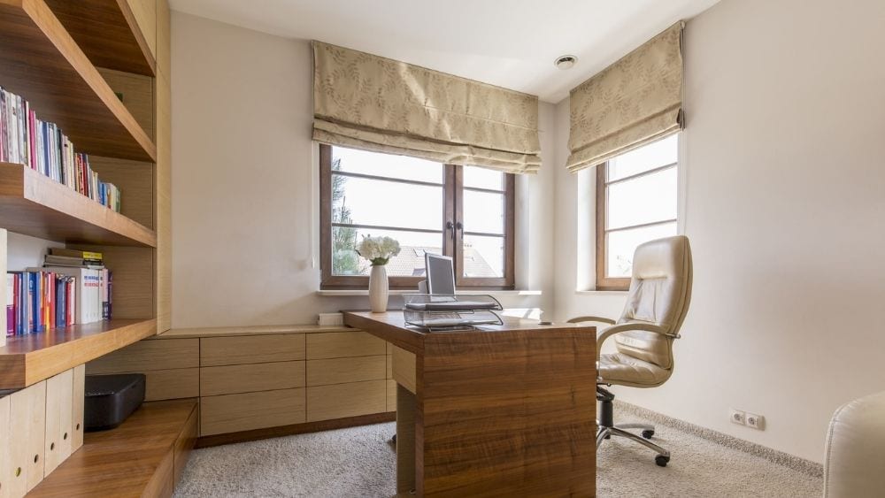 Floating desk facing a custom, built-in bookcase.