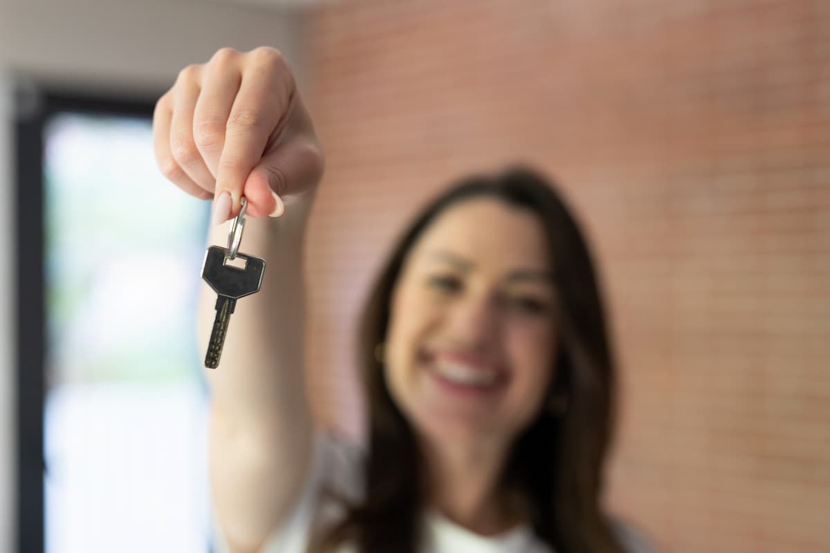Single female homebuyer holding home keys
