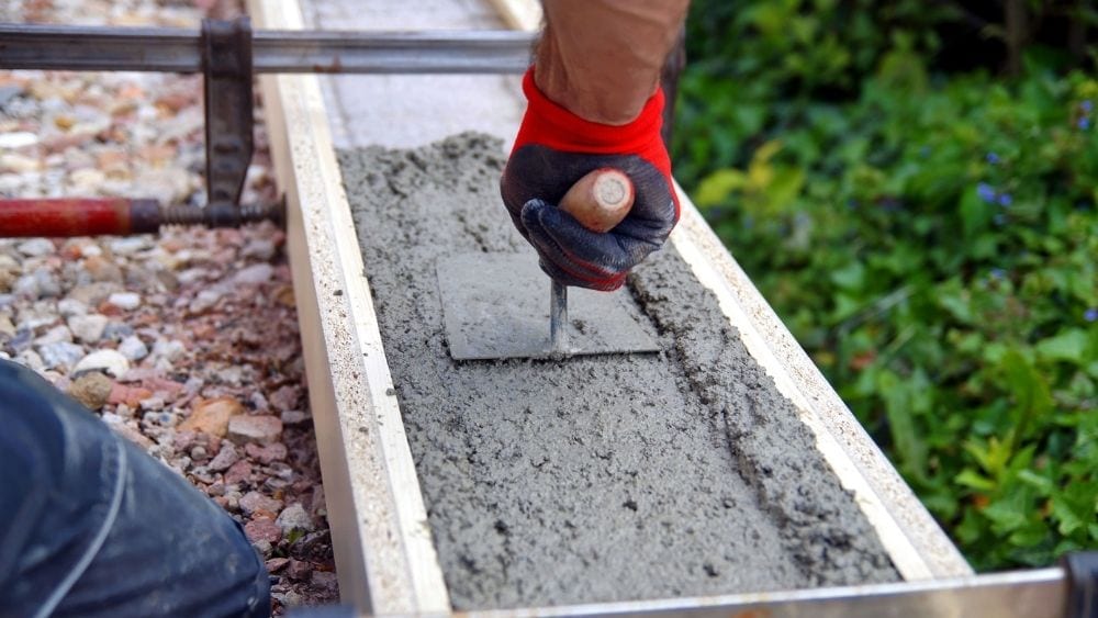 Worker smoothing poured concrete.