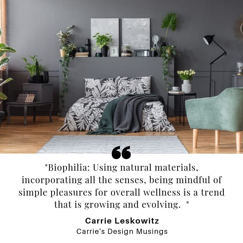 A bedroom with grey walls and a lot of plants sits above the quote: “Biophilia: Using natural materials, incorporating all the senses, being mindful of simple pleasures for overall wellness is a trend that is growing and evolving.”