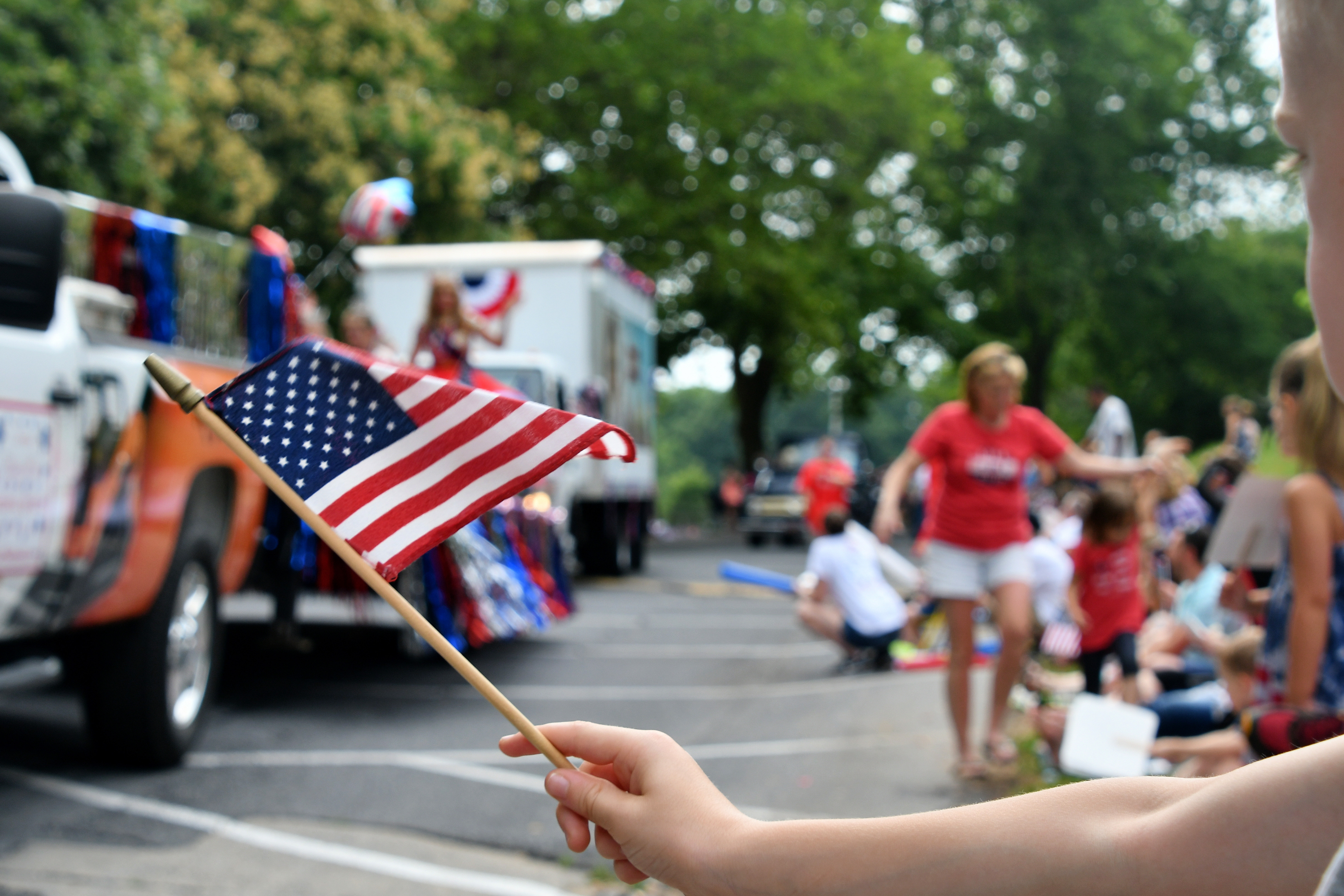 flag waving crowd watching parade floats go by