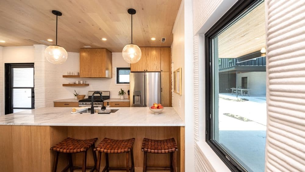 Modern kitchen with wood cabinets and a dining bar.