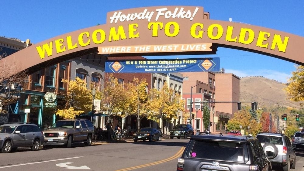 A town square with an archway over the street that reads “Howdy Y’all! Welcome to Golden.”