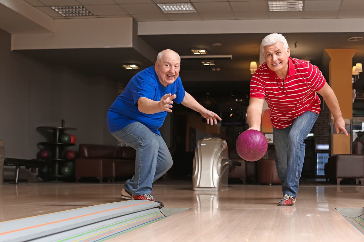 Two seniors bowling at a bowling alley