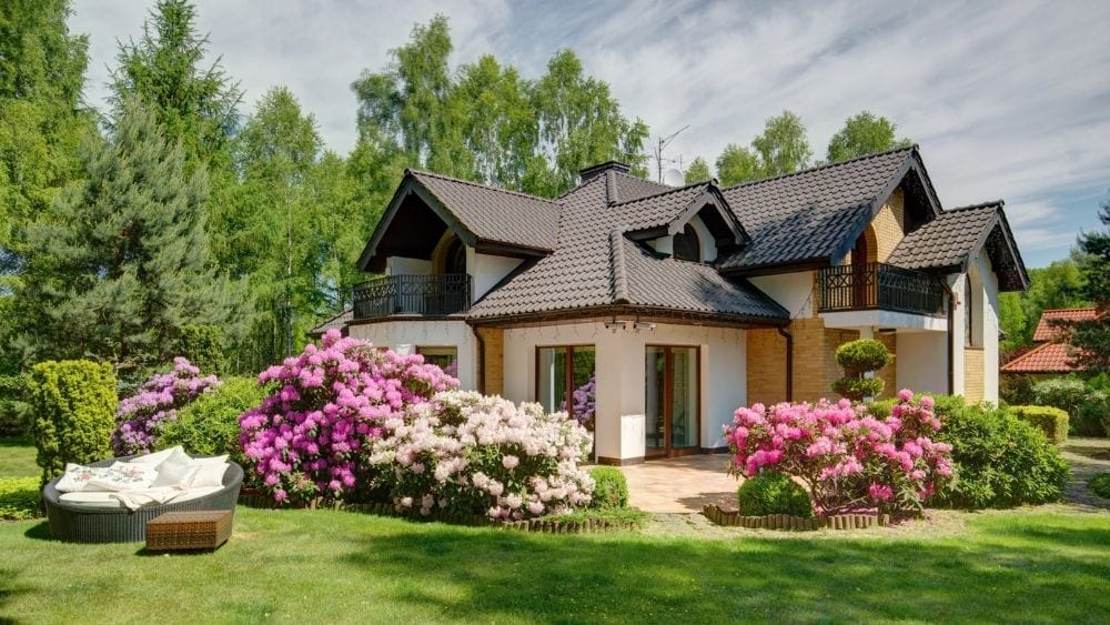 A cottage-style house with gable roofs covered in dark barrel tiles.