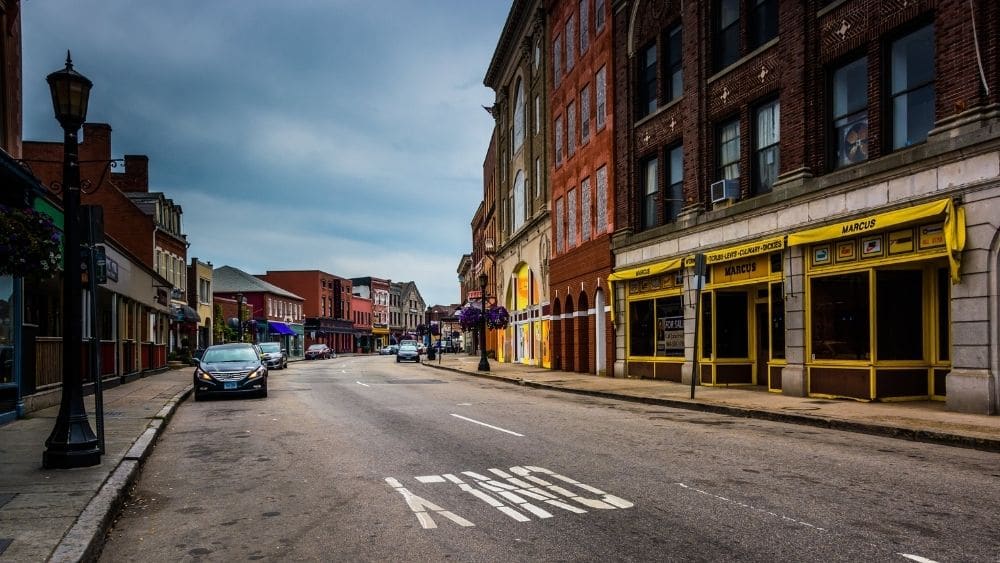 City street with brightly colored buildings on one side in New London, Connecticut.