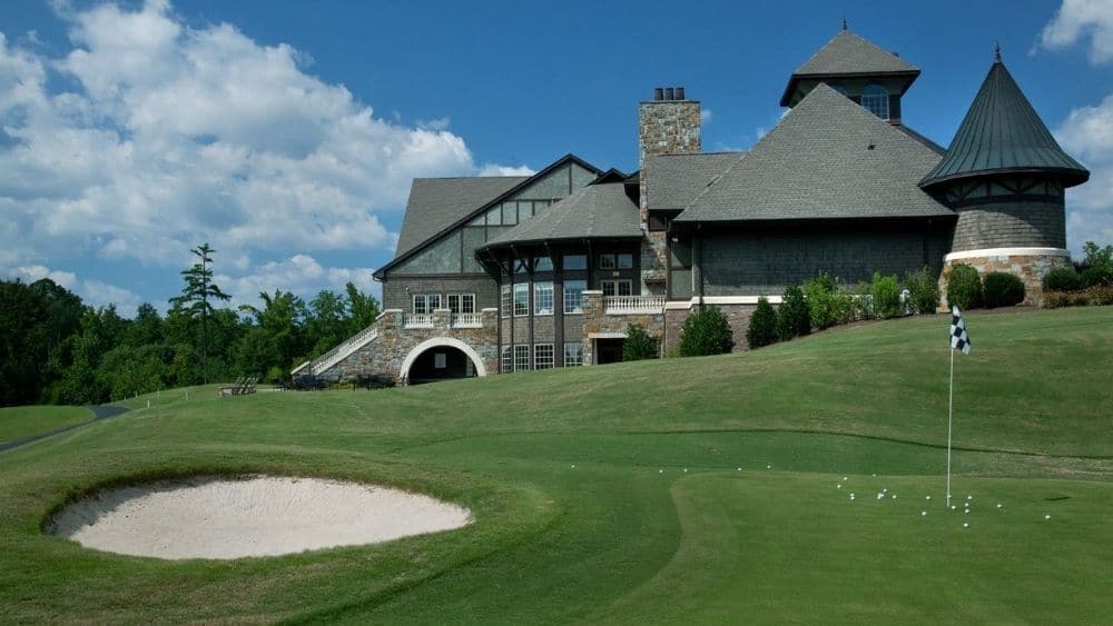 A golf course behind a large amenity center.
