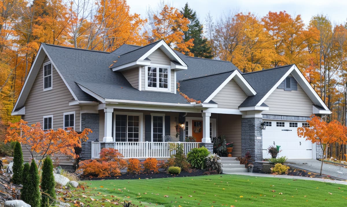 A new home surrounded by fall leaves with front gardens in fall colors