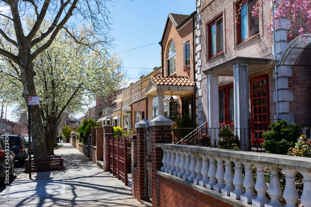 Row of homes with architectural interest and brick fences for small front yards in Queens, NY