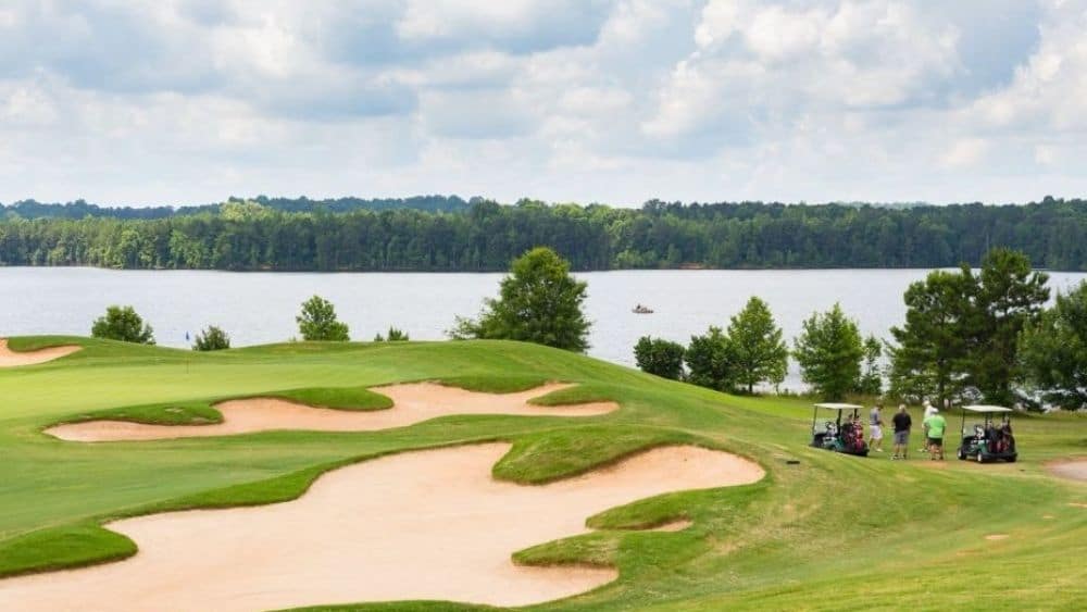 View of a golf course by a lake.
