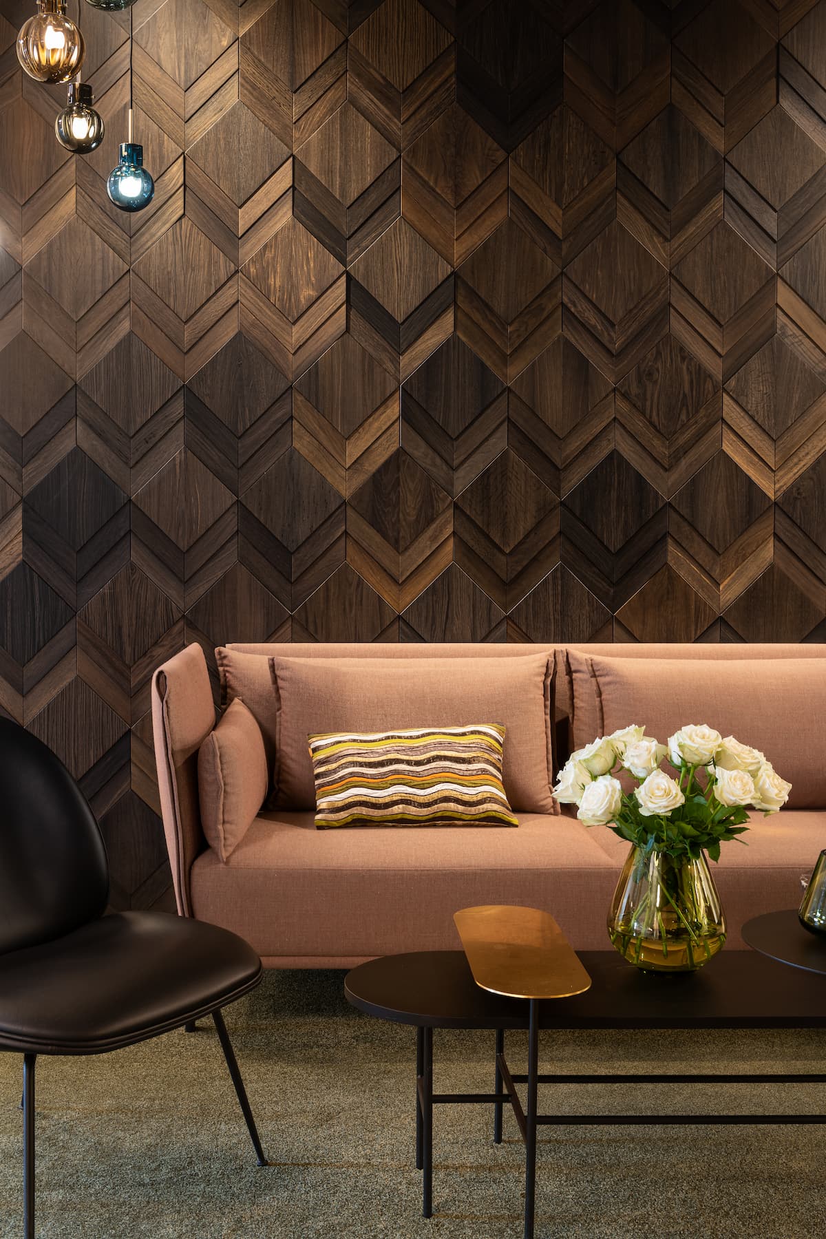 Accent wall with reclaimed wood tiles, with peach sofa in the foreground