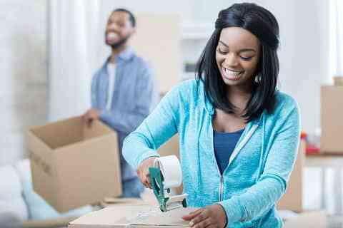 young-woman-finishes-taping-a-moving-box