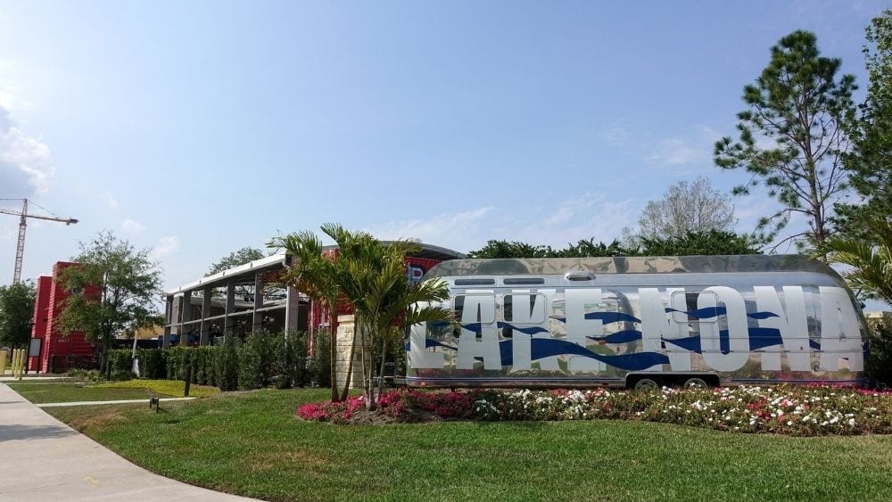 “Lake Nona” painted on the side of an airstream facing a busy street.