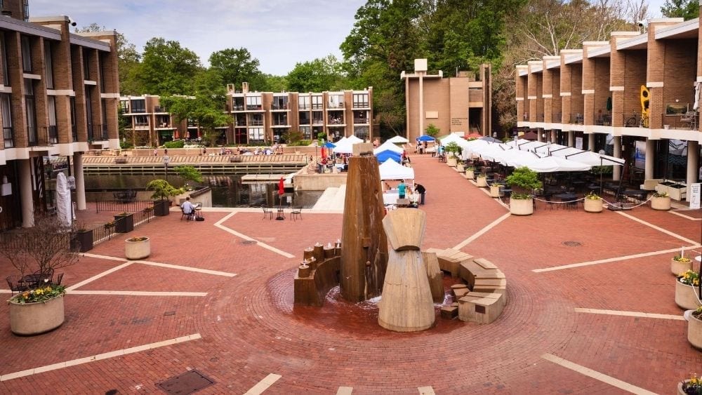 Slight aerial view of an outdoor shopping center with an abstract sculpture in the courtyard.