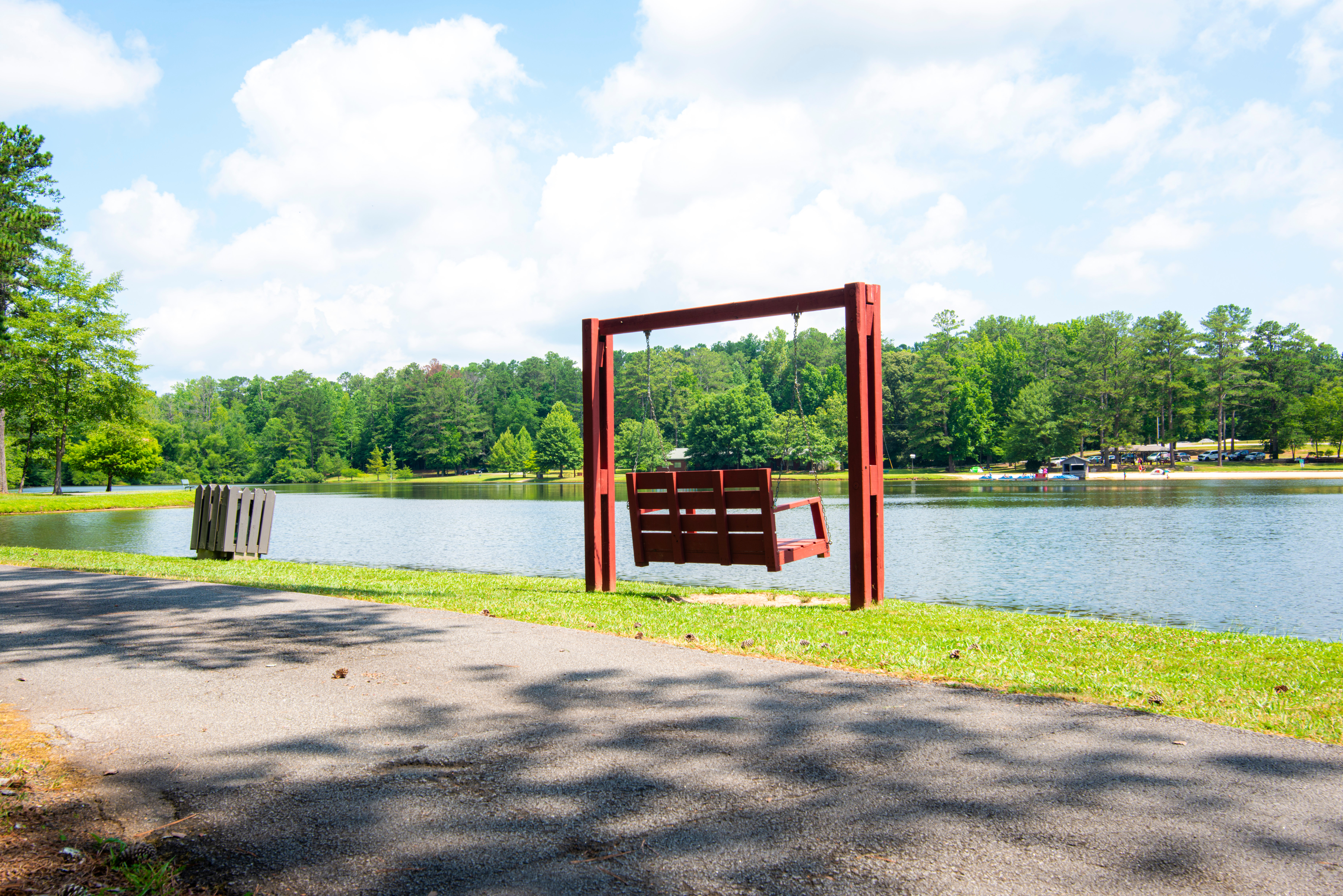 Bench swing at the edge of a lake on a sunny day
