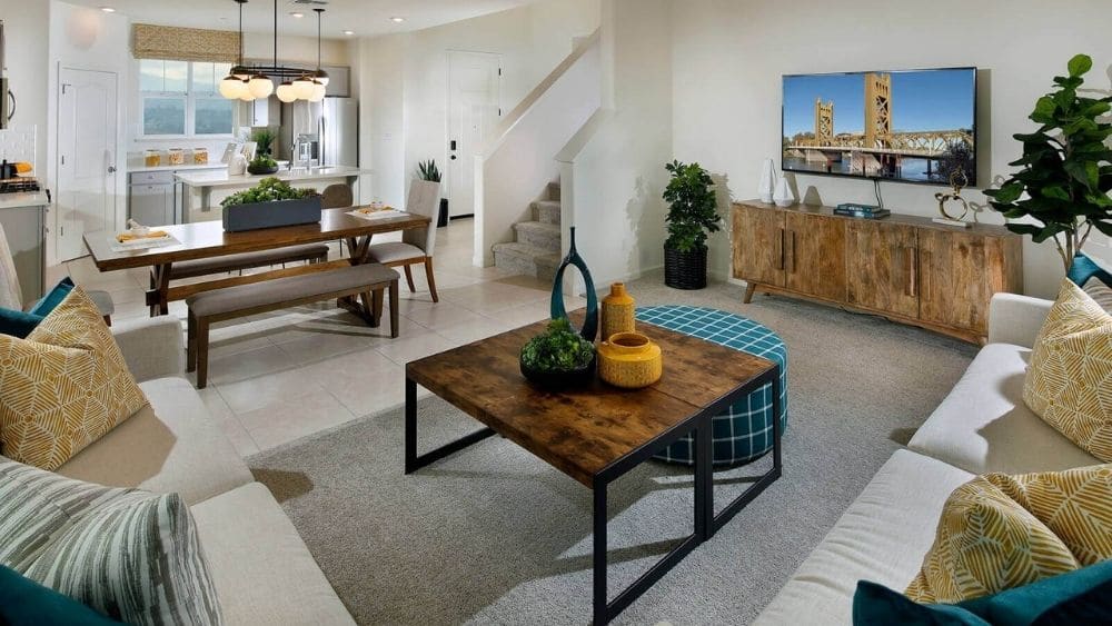 A bright living room with modern furniture and a mustard and teal color scheme.